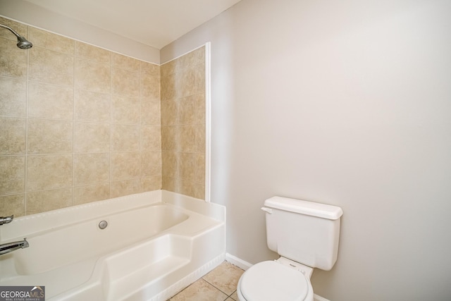 bathroom featuring tiled shower / bath, tile patterned floors, and toilet