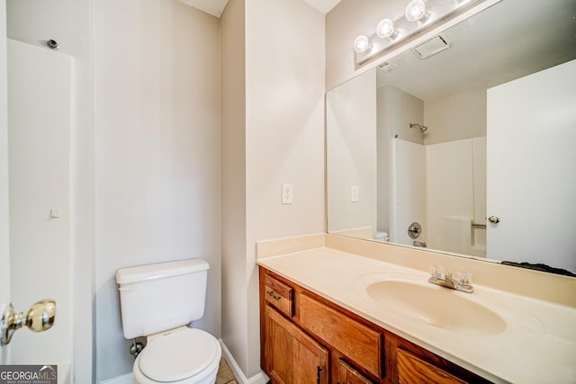 bathroom featuring vanity, tile patterned flooring, toilet, and a shower