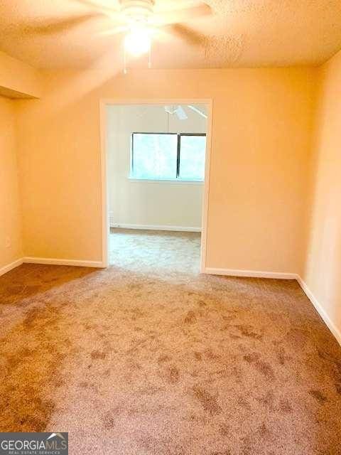 interior space with carpet, a textured ceiling, lofted ceiling, and ceiling fan