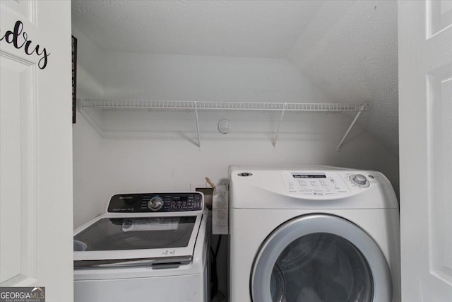 clothes washing area featuring washer and dryer and a textured ceiling