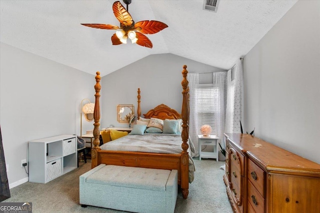 bedroom featuring ceiling fan, vaulted ceiling, light colored carpet, and a textured ceiling