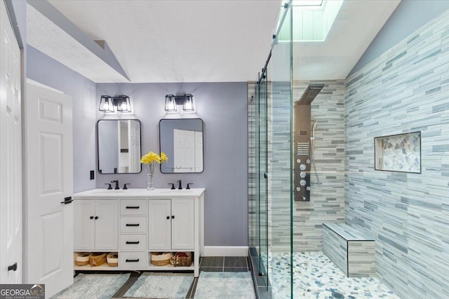 bathroom with walk in shower, lofted ceiling, tile patterned flooring, and vanity