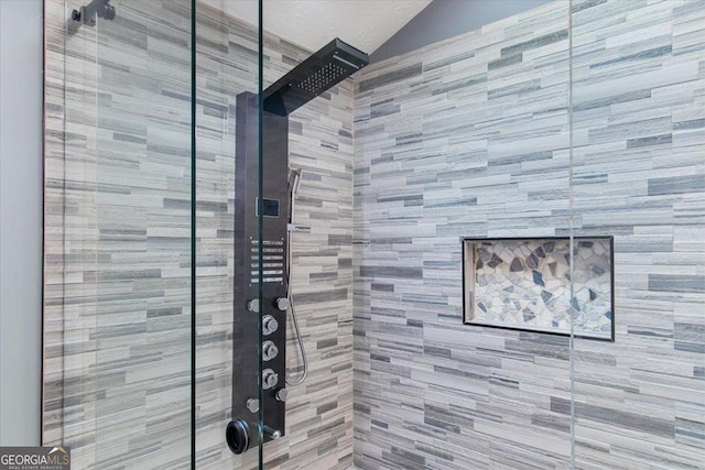 interior details featuring tiled shower