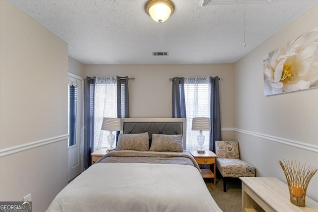 bedroom with carpet floors and a textured ceiling