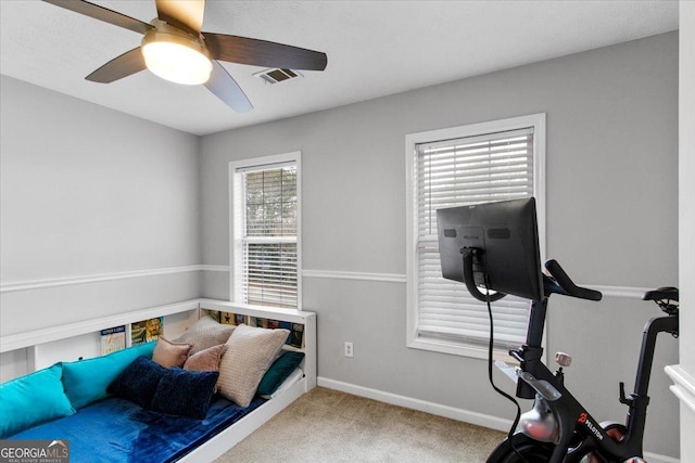 exercise area with ceiling fan and light carpet