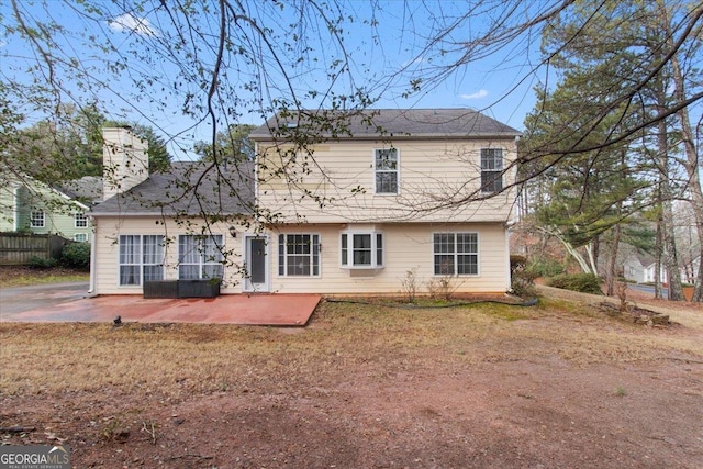 rear view of house with a yard and a patio