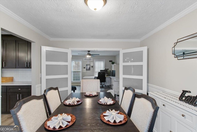 dining room featuring crown molding, light hardwood / wood-style flooring, and a textured ceiling