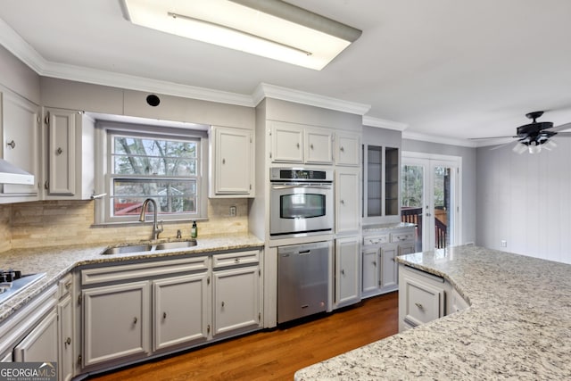 kitchen with sink, backsplash, dark hardwood / wood-style flooring, ornamental molding, and stainless steel appliances