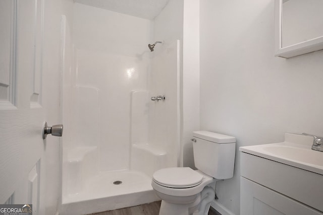 bathroom with vanity, toilet, a textured ceiling, and a shower