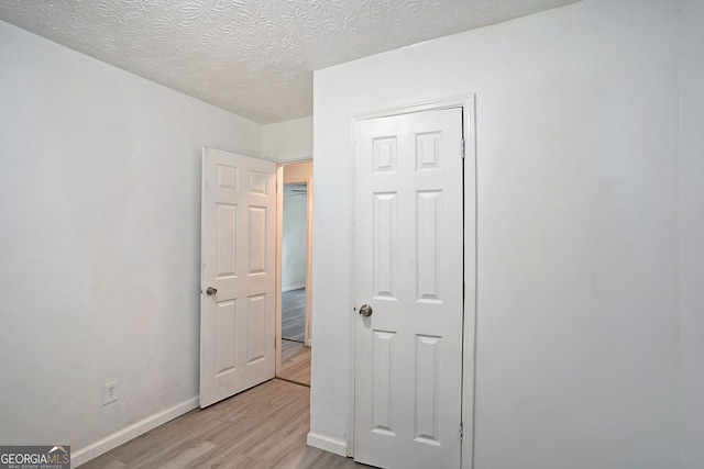 bedroom with light hardwood / wood-style flooring and a textured ceiling