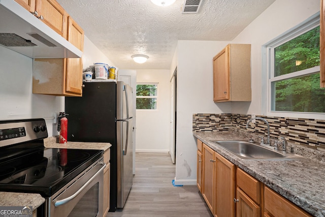 kitchen featuring sink, light hardwood / wood-style flooring, backsplash, electric range, and a textured ceiling