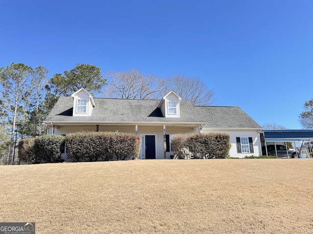 cape cod-style house featuring a detached carport, roof with shingles, and a front lawn