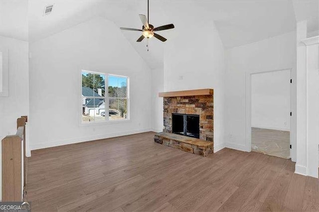 unfurnished living room featuring hardwood / wood-style flooring, a fireplace, high vaulted ceiling, and ceiling fan