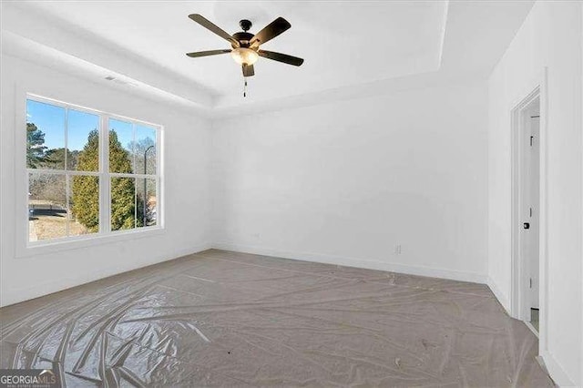 unfurnished room with a raised ceiling and ceiling fan