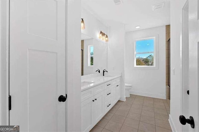 bathroom featuring vanity, a wealth of natural light, tile patterned floors, and toilet