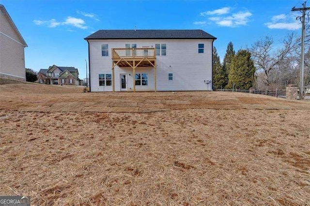 rear view of house featuring a balcony and a lawn