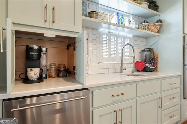 kitchen featuring open shelves, light countertops, backsplash, a sink, and dishwasher