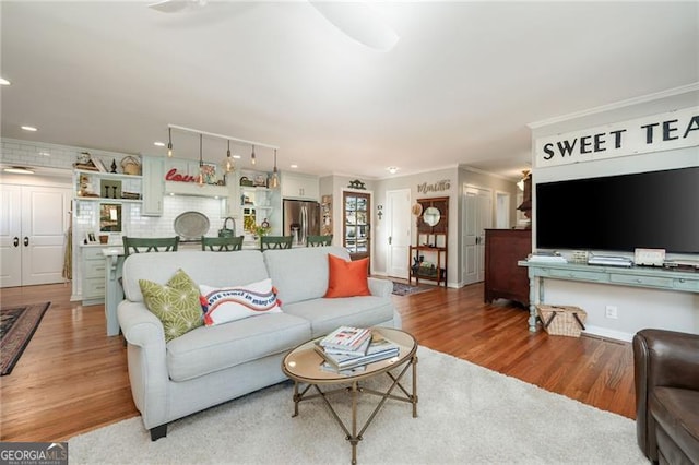 living area with recessed lighting, wood finished floors, and crown molding