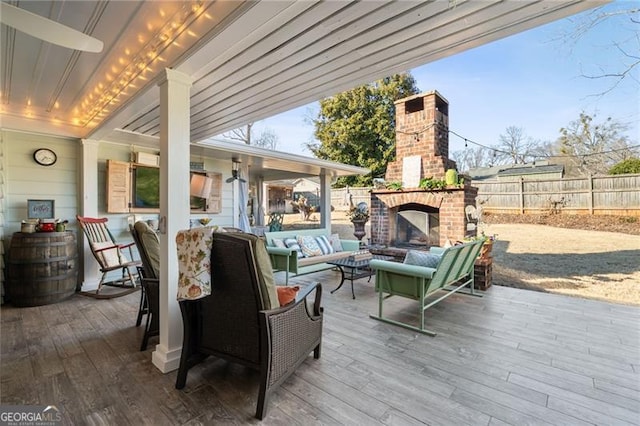 wooden deck featuring an outdoor living space with a fireplace and fence