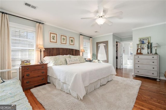 bedroom featuring ornamental molding, a ceiling fan, visible vents, and wood finished floors