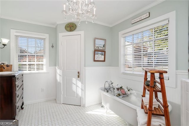 interior space featuring a wainscoted wall, ornamental molding, a freestanding tub, and vanity