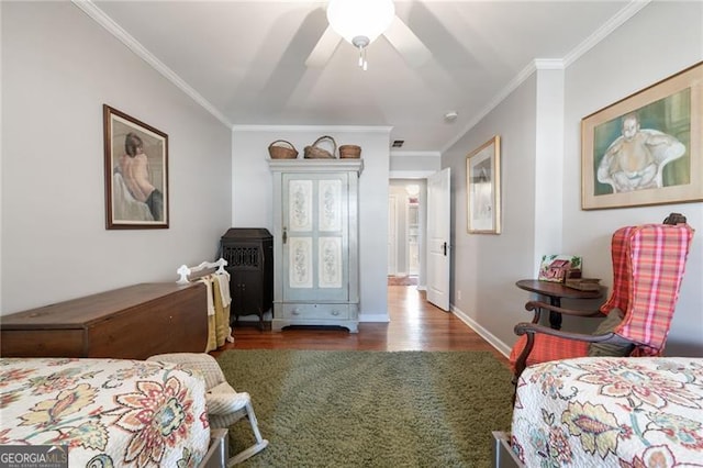 bedroom featuring ornamental molding, wood finished floors, a ceiling fan, and baseboards