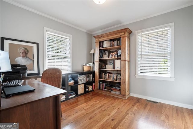 office space featuring light wood-type flooring, baseboards, visible vents, and ornamental molding