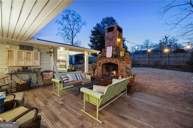 deck featuring an outdoor living space with a fireplace and fence