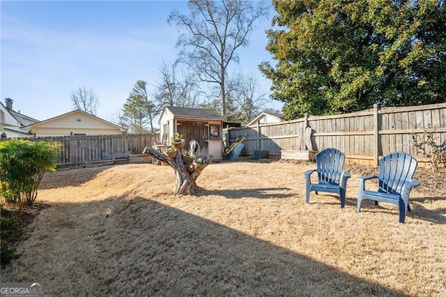 view of yard featuring a fenced backyard, an outdoor structure, and a storage shed