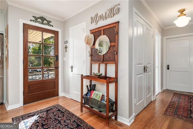 foyer entrance featuring light wood-type flooring, baseboards, and ornamental molding