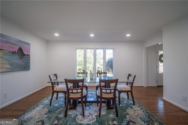 dining space featuring ornamental molding and dark hardwood / wood-style flooring