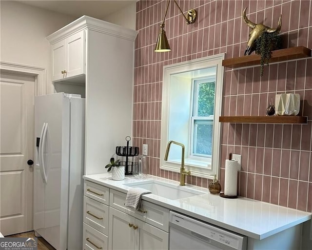 kitchen featuring white cabinetry, sink, white appliances, and tile walls