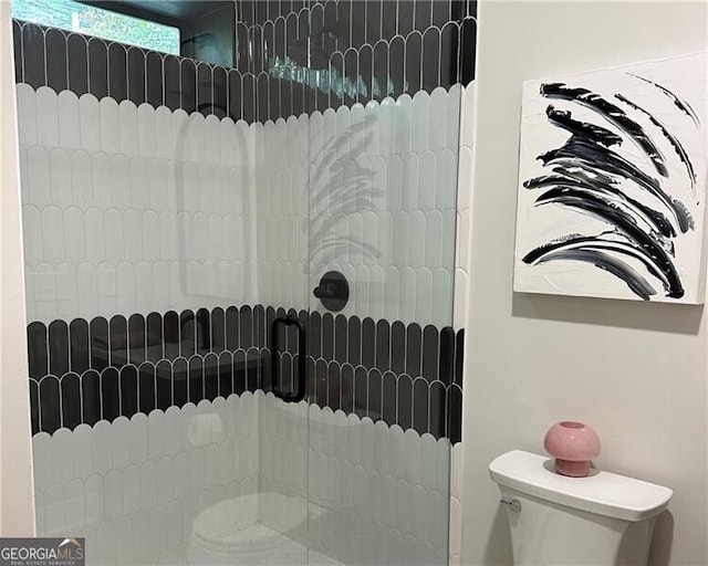 interior details with a tile shower and toilet