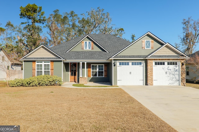 craftsman inspired home with a garage and a front lawn