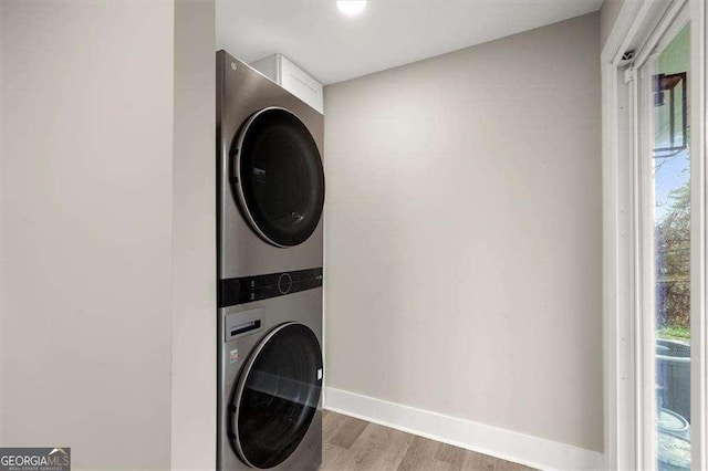 clothes washing area featuring stacked washer / drying machine and hardwood / wood-style floors