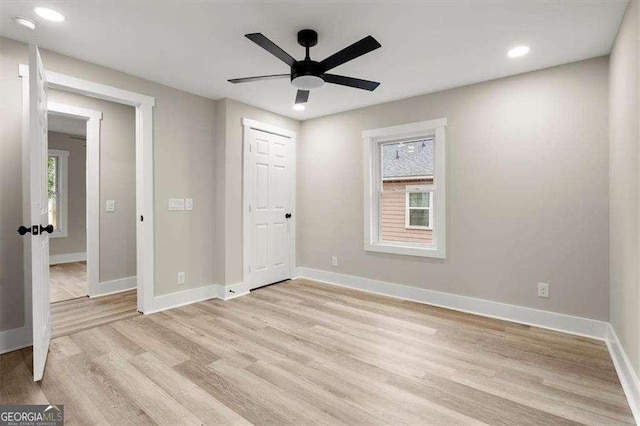 unfurnished bedroom featuring multiple windows, a closet, ceiling fan, and light hardwood / wood-style floors