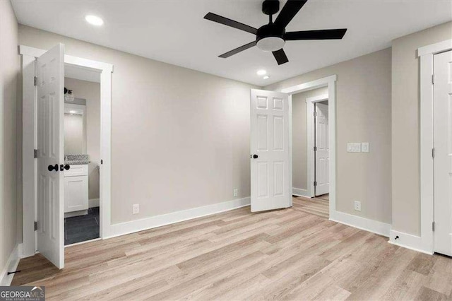 unfurnished bedroom featuring ensuite bath, light hardwood / wood-style flooring, and ceiling fan