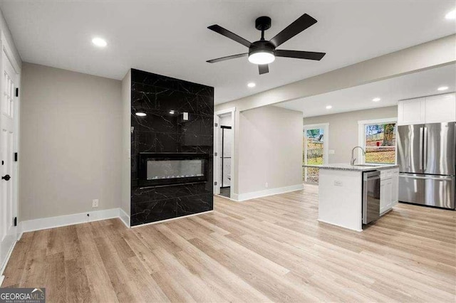 kitchen with white cabinetry, sink, light hardwood / wood-style flooring, and appliances with stainless steel finishes