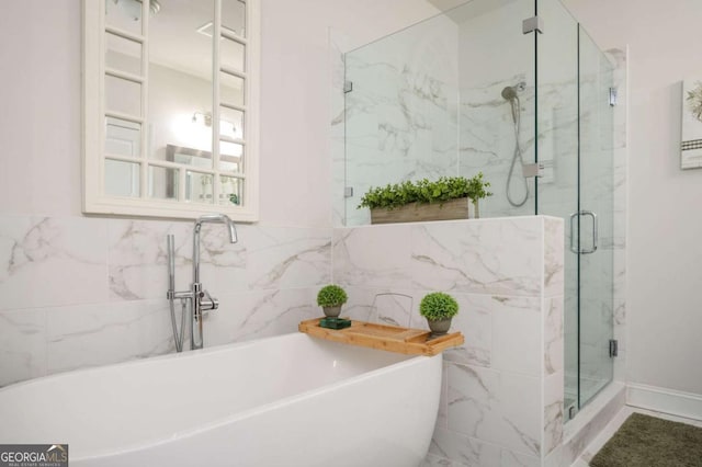 bathroom with separate shower and tub and tile walls