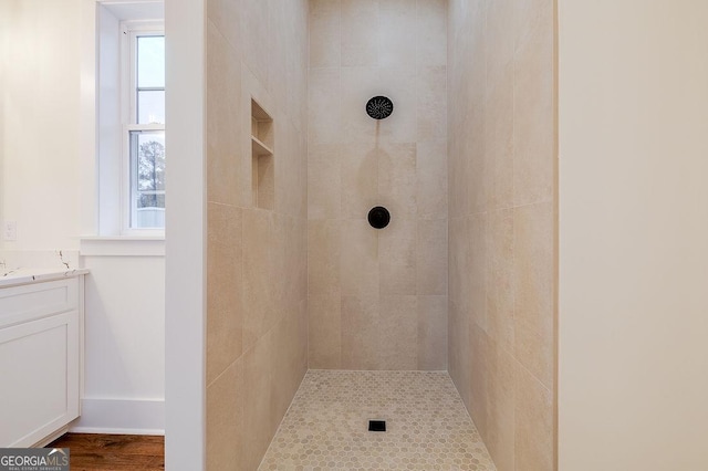 bathroom with vanity and tiled shower