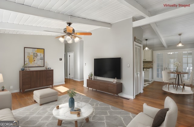 living room featuring ceiling fan, wood-type flooring, and beamed ceiling