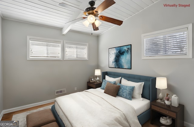 bedroom featuring hardwood / wood-style floors, beam ceiling, wooden ceiling, and ceiling fan