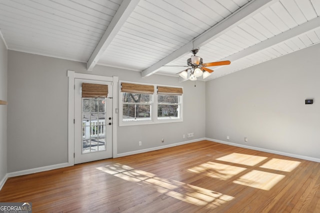 unfurnished room with a healthy amount of sunlight, beam ceiling, and light hardwood / wood-style floors