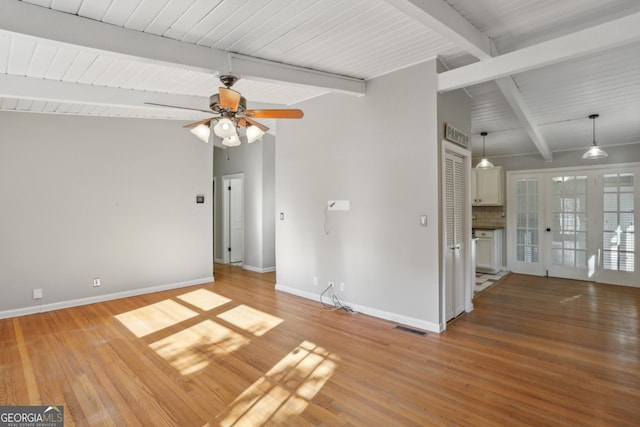 spare room with hardwood / wood-style flooring, ceiling fan, and lofted ceiling with beams