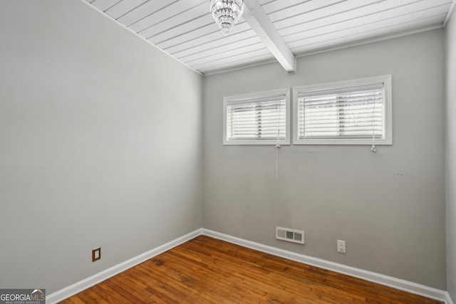 empty room with wood ceiling, hardwood / wood-style flooring, and beamed ceiling