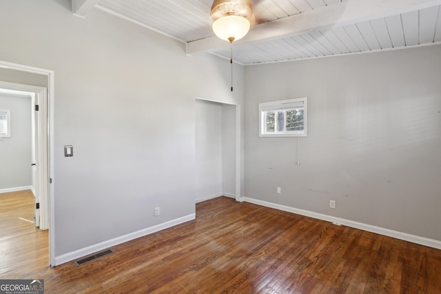 spare room featuring beamed ceiling, hardwood / wood-style flooring, and wooden ceiling