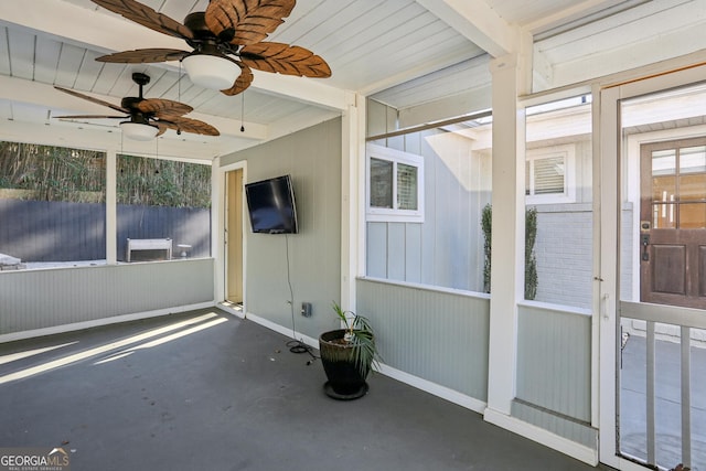 unfurnished sunroom featuring beam ceiling