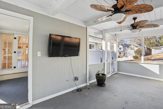 unfurnished sunroom featuring ceiling fan and beam ceiling