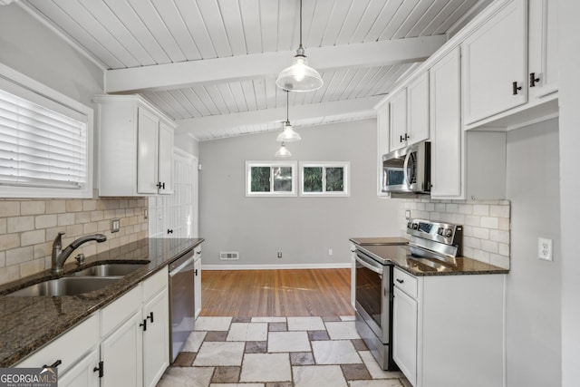 kitchen with sink, tasteful backsplash, decorative light fixtures, appliances with stainless steel finishes, and white cabinets