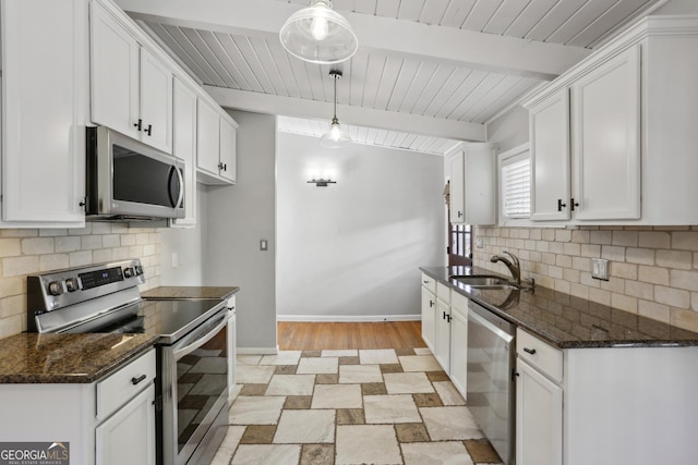 kitchen featuring stainless steel appliances, white cabinetry, hanging light fixtures, and beamed ceiling